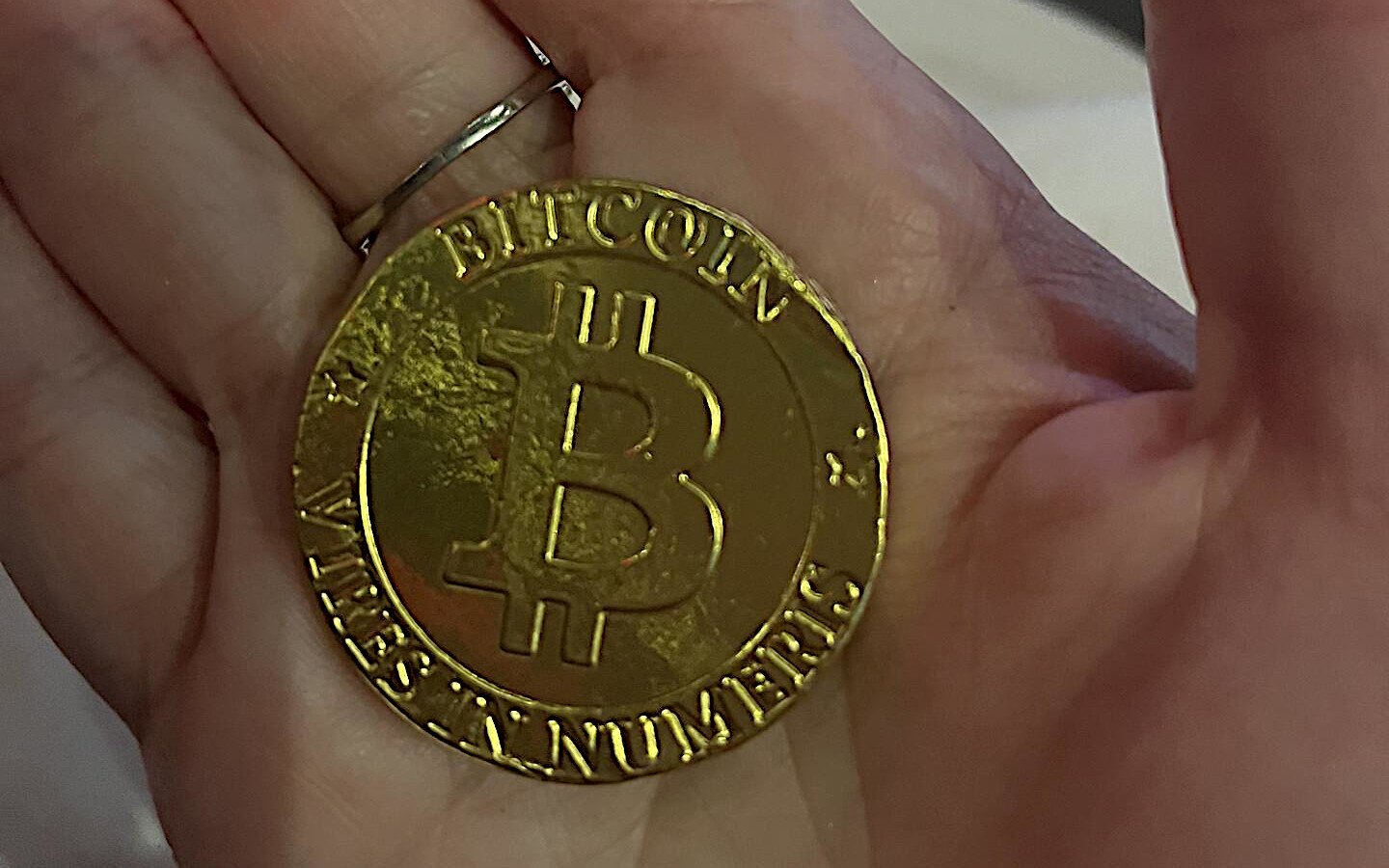 One physical Bitcoin in a hand